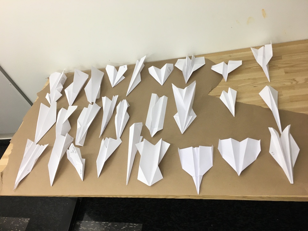 A table covered in folded paper airplanes from a rapid prototyping exercise